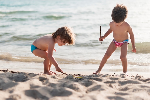 Long shot van kinderen spelen op het strand