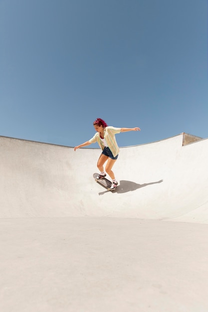 Long shot vrouw op skateboard buiten