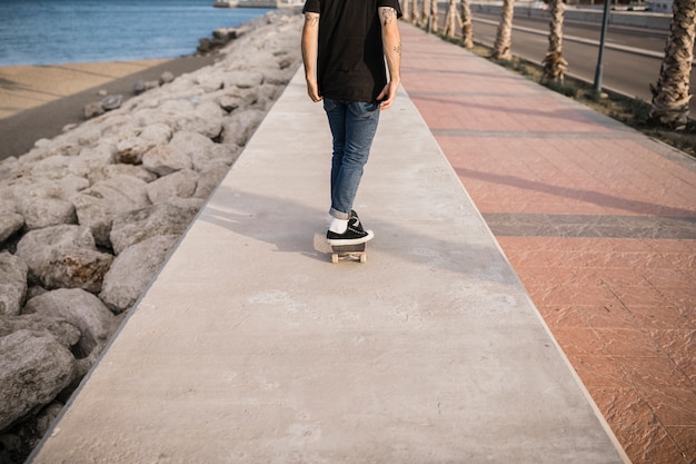 Gratis foto lowsectionmening van een mens die op de muur met een skateboard rijdt