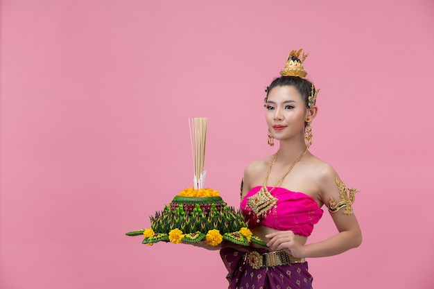 Loy Krathong Festival; vrouw in Thaise traditionele outfit met versierde drijfvermogen