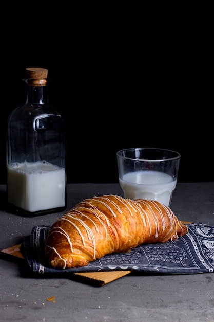 Luchtcroissant met witte room erop en een glas melk