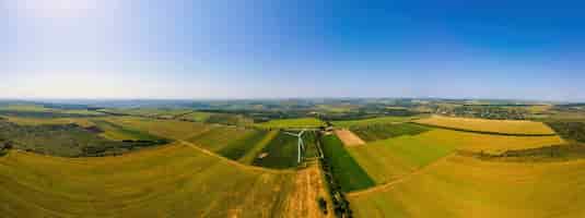 Gratis foto luchtfoto drone panorama uitzicht op werkende windturbine in moldavië brede velden eromheen