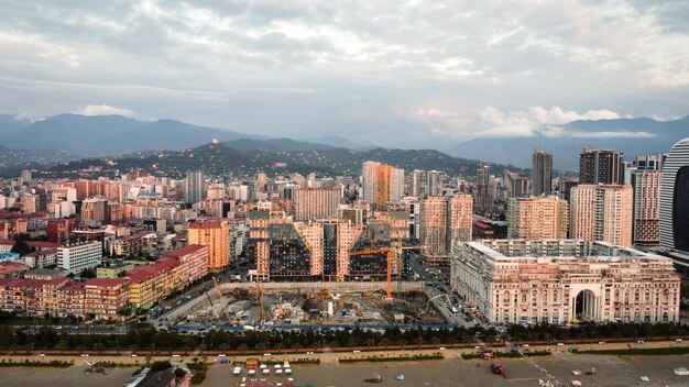 Luchtfoto drone uitzicht op de kustlijn in Batumi Georgia Zwarte Zee gebouwen groen bergen