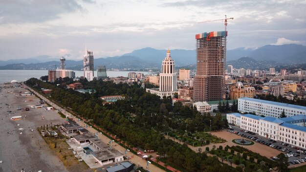 Luchtfoto drone uitzicht op de kustlijn in Batumi Georgia Zwarte Zee gebouwen groen bergen