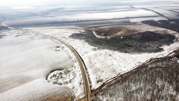 Luchtfoto drone uitzicht op de natuur in de winter in moldavië weg door velden en kaal bos