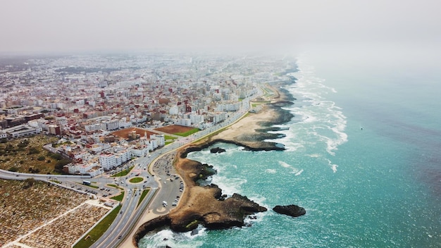 Gratis foto luchtfoto drone weergave van rabat marokko atlantische oceaan rotsachtige kustlijn met woongebouwen