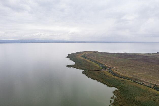 Luchtfoto op enorm meer met een groene sre en vroege avondlucht