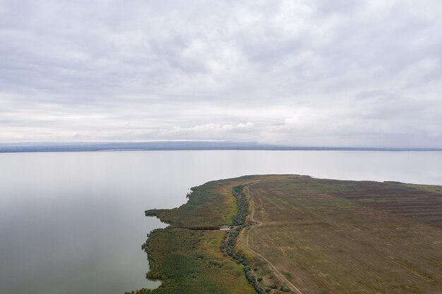 Luchtfoto op enorm meer met een groene sre en vroege avondlucht