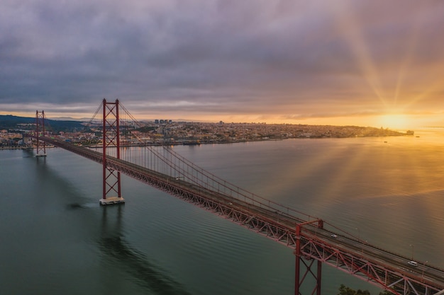 Gratis foto luchtfoto shot van een hangbrug in portugal tijdens een prachtige zonsondergang