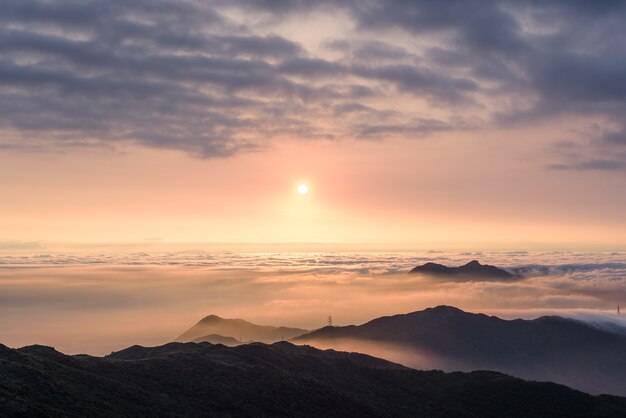 Luchtfoto van bergen onder een bewolkte hemel bij zonsondergang