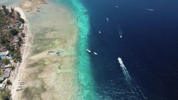 Luchtfoto van de boten die op de blauwe oceaan aan de kust varen