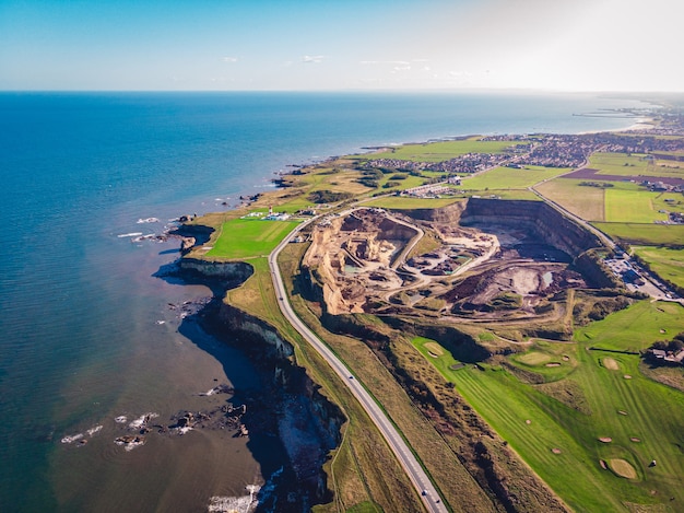 Luchtfoto van een helderblauwe zee en een met gras begroeide kust