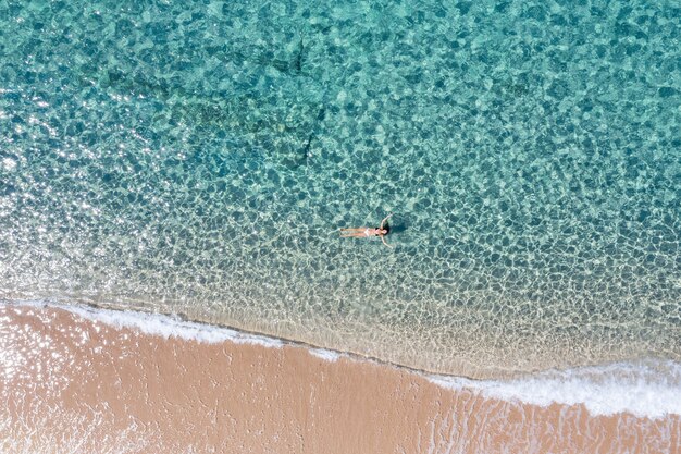 Luchtfoto van een meisje dat in een geweldige zee zwemt