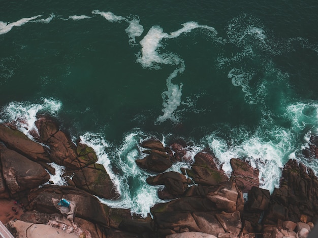 Luchtfoto van een rotsstrand en de zee met waterspatten