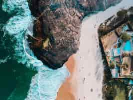 Gratis foto luchtfoto van een strand in rio de janeiro met huizen op de berg