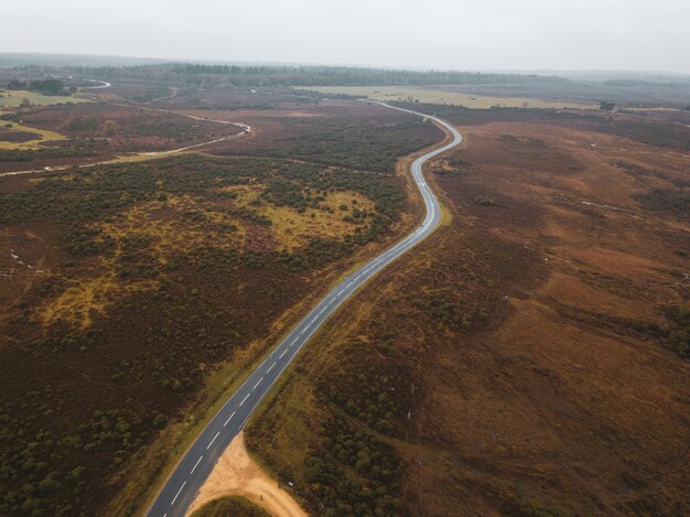 Luchtfoto van een weg in het midden van een groen landschap in het New Forest, in de buurt van Brockenhurst, Verenigd Koninkrijk