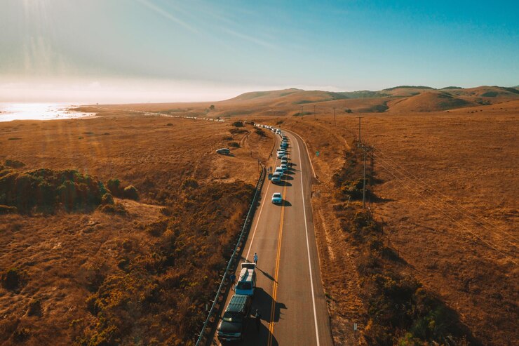 Gratis Foto luchtfoto van een wegverkeer in prachtige natuur onder een blauwe heldere hemel