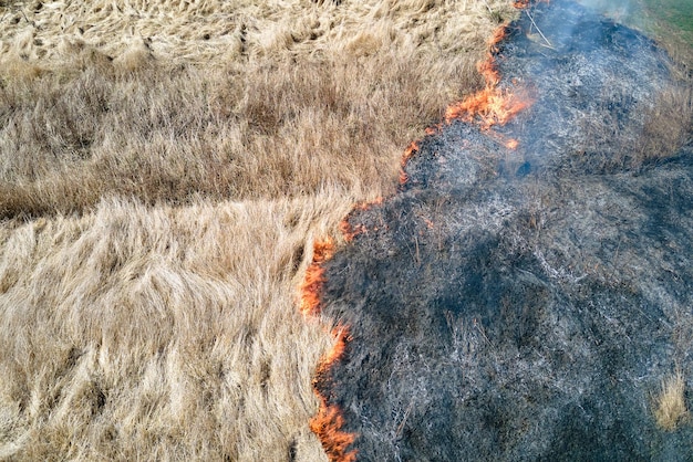 Luchtfoto van grasland dat tijdens het droge seizoen met rood vuur brandt. natuurramp en klimaatverandering concept.