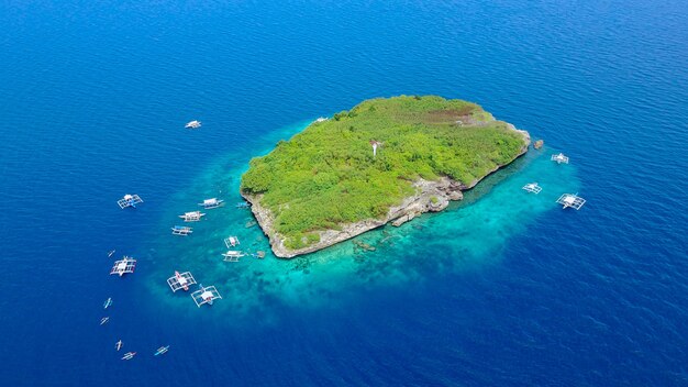 Luchtfoto van het zandstrand met toeristen zwemmen in prachtig helder zeewater van het Sumilon eiland strand landend in de buurt Oslob, Cebu, Filipijnen. - Boost up color Processing.