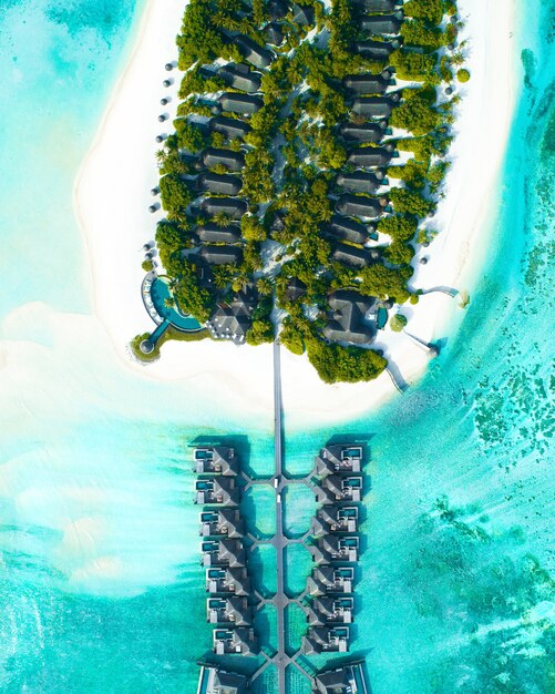 Luchtfoto van huizen gebouwd over de zee en op het land met bomen op de Malediven