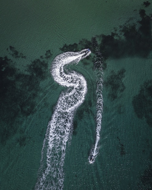 Luchtfoto van jachten die in de zee cruisen en spattende sporen achterlaten
