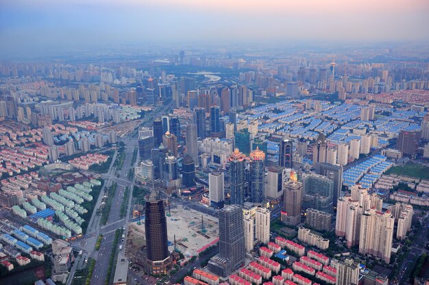 Luchtfoto van Shanghai bij zonsondergang met stedelijke wolkenkrabbers over de rivier