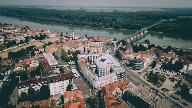 Luchtfoto van stadsgebouwen met een brug over de rivier in de buurt van bomen en planten