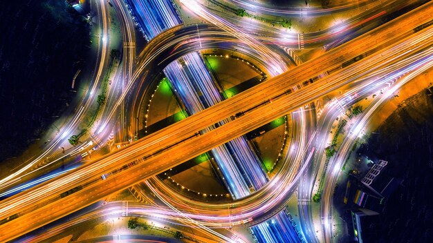 Luchtfoto van verkeer in rotonde en snelweg 's nachts.