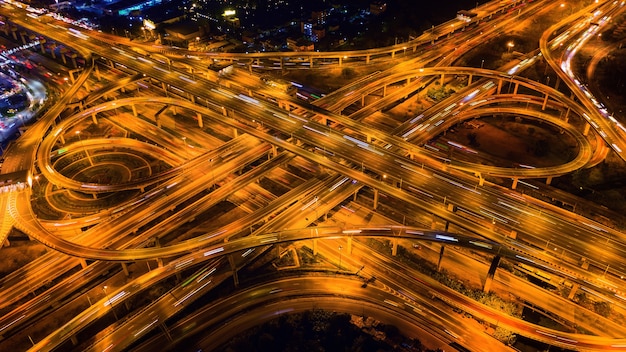 Luchtfoto van verkeer op enorme snelweg kruising 's nachts.