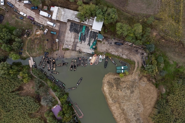 Luchtfoto van vissers pier dok met veel vissersboten geparkeerd in een haven. Vogelperspectief van bovenaf van kleine vissershaven.