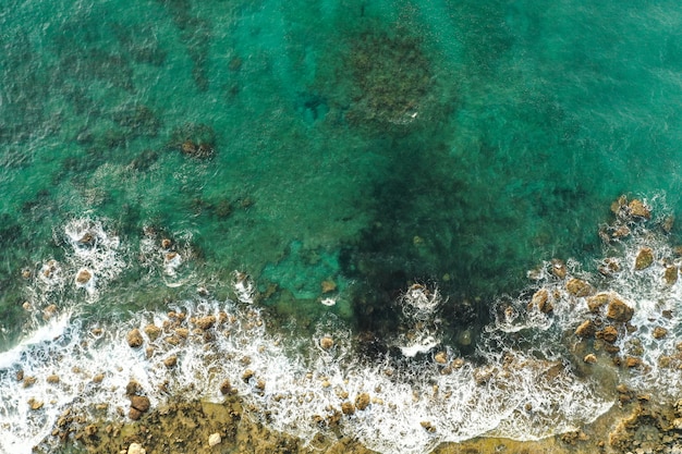 Luchtfoto van zee die rotsachtige kust ontmoet