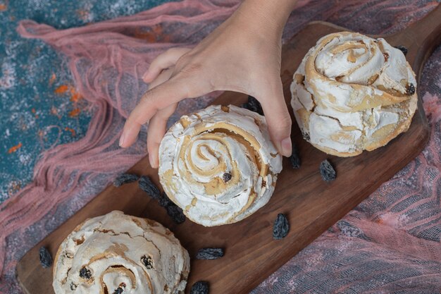 Luchtige meringue muffins met zwarte droge druiven op tafel.