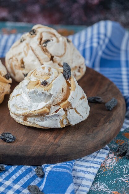 Luchtige meringue muffins met zwarte droge druiven op tafel.