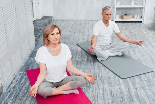 Luchtmening van een gezond paar die op yogamat uitoefenen