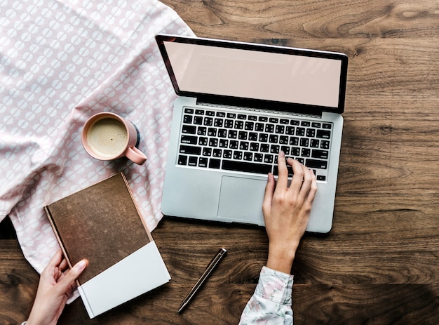 Luchtmening van een vrouw die computerlaptop op houten lijst met behulp van