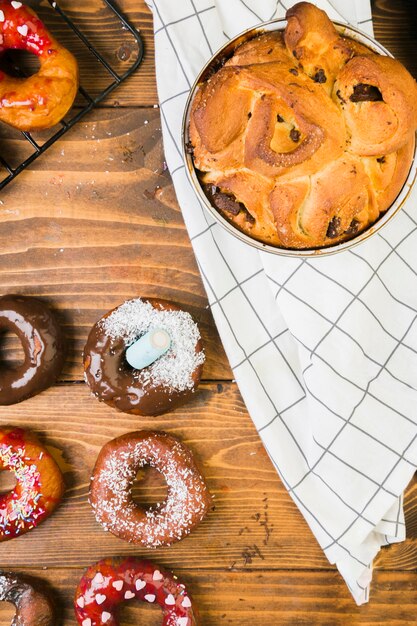 Luchtmening van smakelijke dessert en chocoladedoughnut op houten bureau