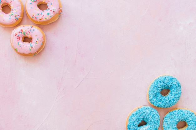 Luchtmening van smakelijke donuts op roze achtergrond