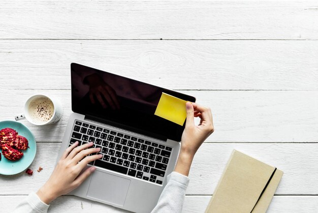 Luchtmening van vrouw die computerlaptop op het houten concept van de lijstwerkruimte met behulp van