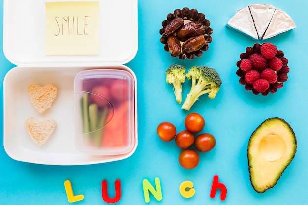 Lunch die dichtbij voedsel en lunchbox schrijft