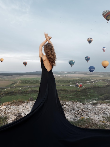 Luxe vrouw in jurk met ballonnen achterkant