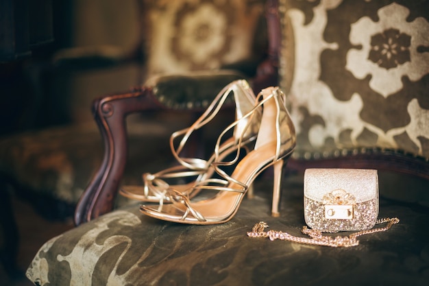 Luxe vrouw mode-accessoires, gouden hakken, kleine avondtasje, elegante stijl, vintage stijl, sandalen schoeisel