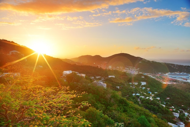Maagdeneilanden St Thomas zonsopgang met kleurrijke wolk, gebouwen en strandkustlijn.
