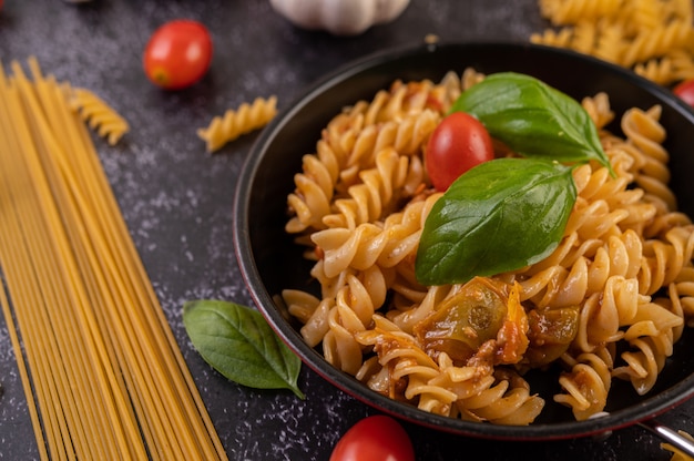 Macaroni gebakken met tomaten en basilicum in de pan