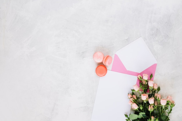 Macaroons dichtbij envelop en boeket