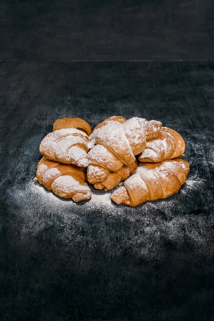 Macrobeeld van croissants met poedersuiker op grijze lijst.