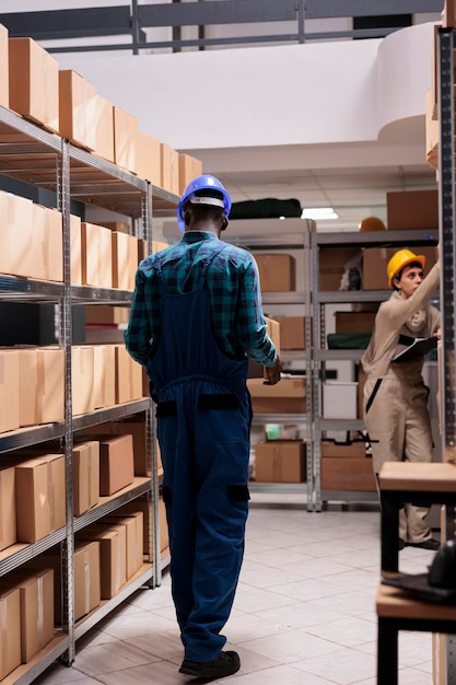 Magazijnlader met kartonnen container in het magazijn van de bezorgservice