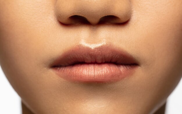 Magische looks. Close-up lippen en wangen van mooie Aziatische vrouw geïsoleerd op wit.