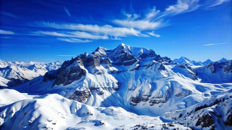 Gratis Foto majestueuze met sneeuw bedekte bergen tegen een blauwe hemel