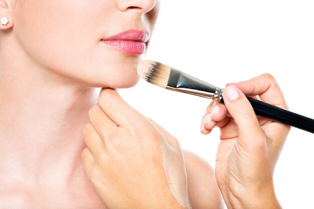 Make-up artiest vloeibare tonale foundation toe te passen op het gezicht van de vrouw