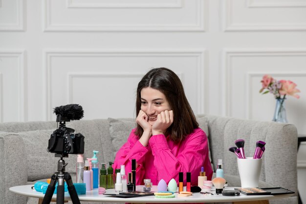 Make-up blogger mooie schattige brunette jonge meid die blog opneemt op camera die in de camera kijkt